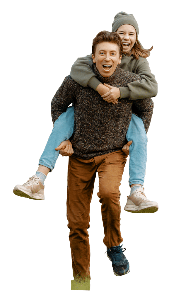 Man carrying young daughter on his back running through grassy field; heating services.